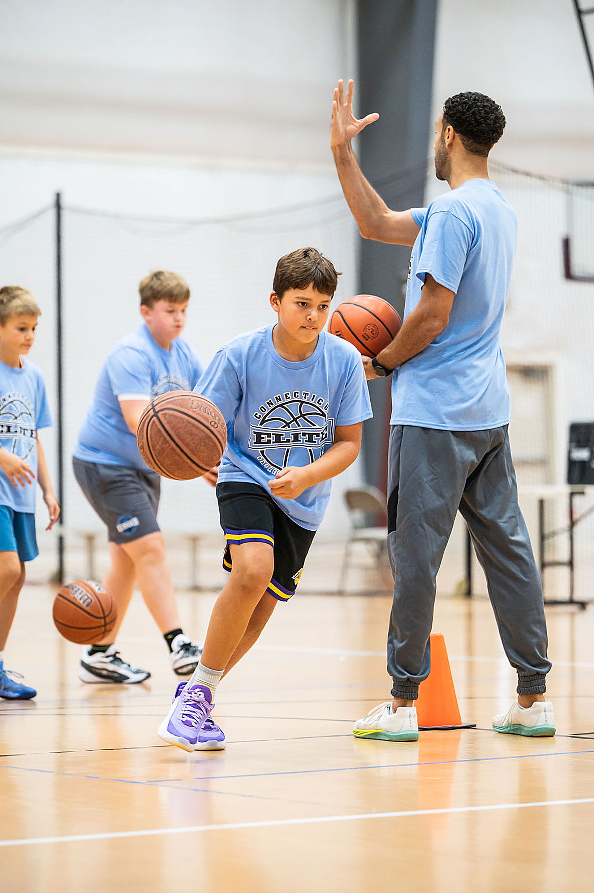 Connecticut Elite coach guiding a young player dribbling through a drill